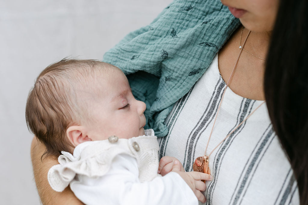 mum-looking-down-at-sleeping-baby-in-arms-with-muslin-draped-on-shoulder-bon-and-bear