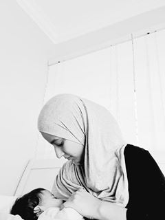 muslim-woman-in-hijab-breastfeeding-baby-holding-hand-bon-and-bear